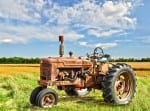 red old rusty tractor in a field