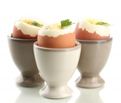 Boiled eggs in egg cup, isolated on white