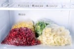 Frozen berries and vegetables in bags in freezer for meal preparation