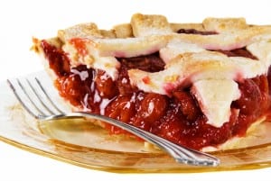 cherry pie served on a gold antique glass plate with a fork.