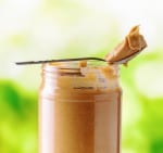 Jar of peanut butter on nature background.