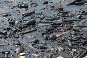 Plastic bottles and garbage floating on fuel oil contaminated ocean water