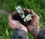 Man holding soil with dollars spending