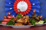Super Bowl Sunday football party celebration food plates with chicken buffalo wings, meat balls, hot dogs and USA party decorations.