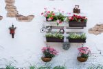 White storage industrial pallet used in gardening for a wall decoration as a shelf for flowerpots and other objects. Useful and interesting ideas what to do with pallets in garden,house or backyard.