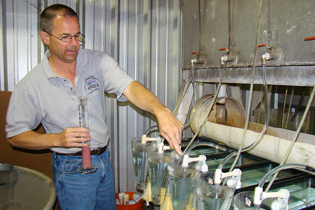 ARS aquatic toxicologist Dave Straus adds fish eggs to hatching chambers in a study at Keo Fish Farm. Photo by Cindy Ledbetter, Agricultural Research Service